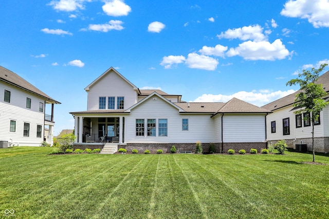 rear view of house with a porch, a lawn, and central AC unit