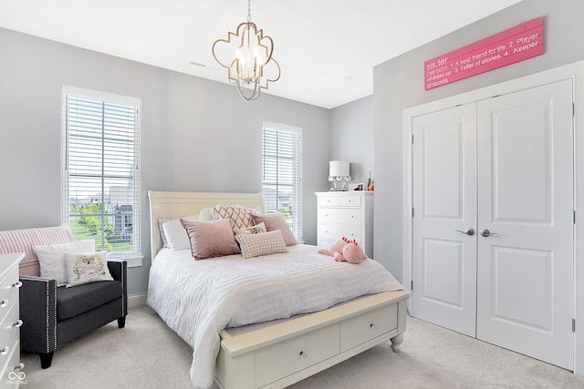 bedroom with light carpet, a chandelier, and a closet