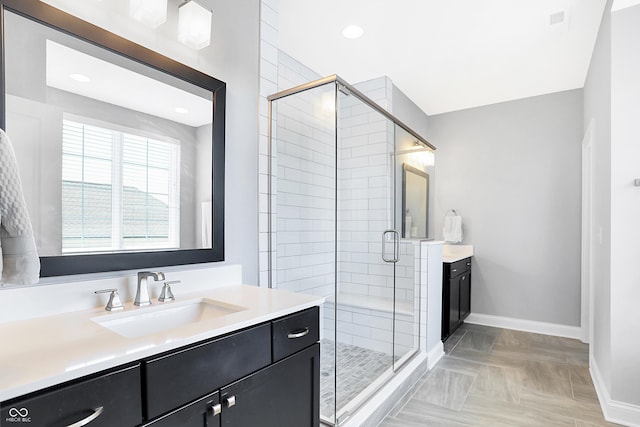 bathroom featuring recessed lighting, baseboards, a shower stall, and vanity