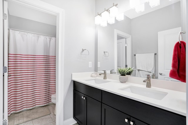 bathroom with double vanity, toilet, and a sink