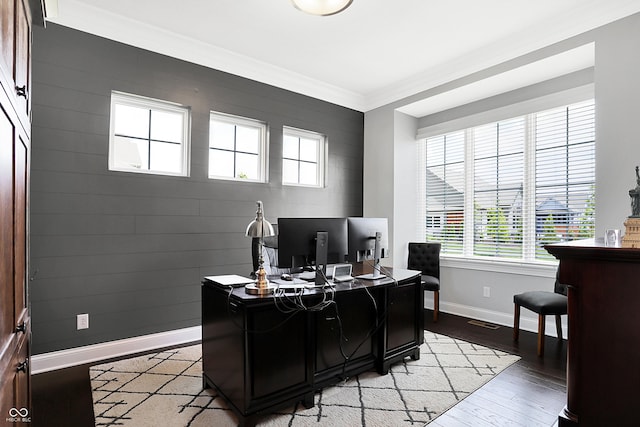 home office with ornamental molding, light wood-type flooring, visible vents, and baseboards