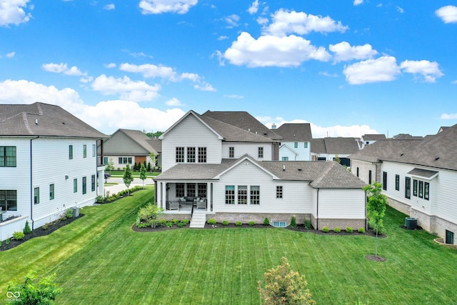 rear view of property with central air condition unit, a residential view, a porch, and a yard