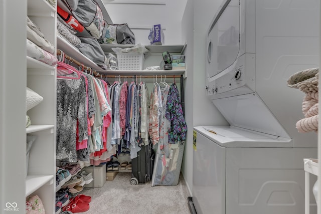 spacious closet with stacked washer / dryer and carpet flooring