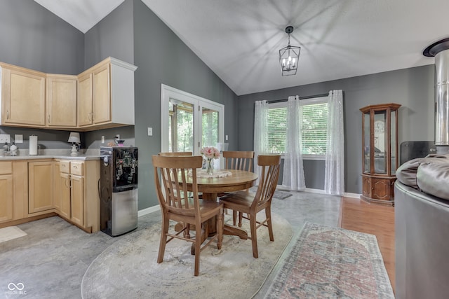 dining area with lofted ceiling, baseboards, and an inviting chandelier