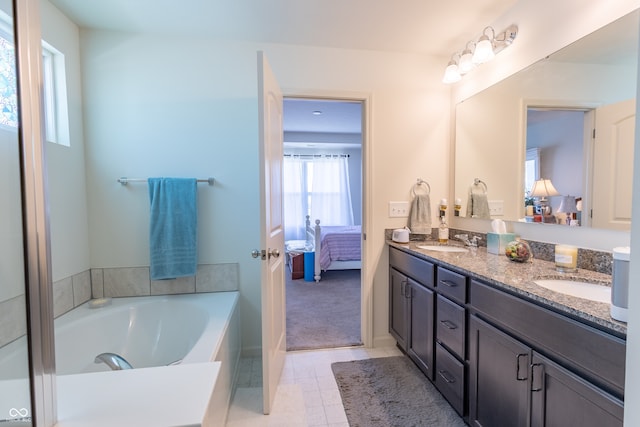 bathroom with dual sinks, tile flooring, vanity with extensive cabinet space, and a bath to relax in