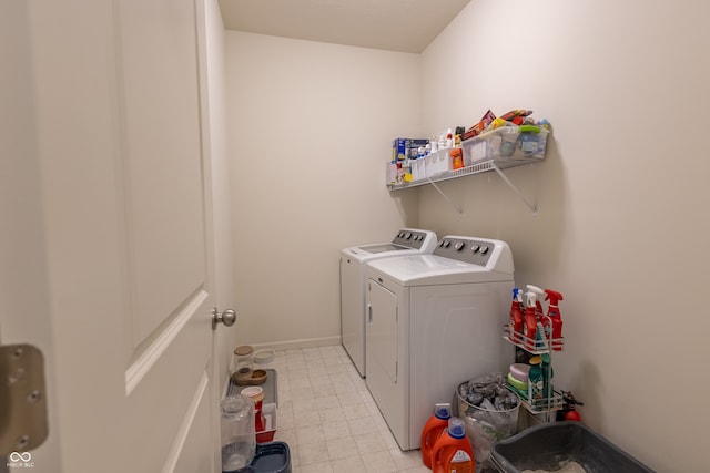 washroom with washer and clothes dryer and light tile floors