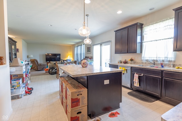 kitchen featuring hanging light fixtures, dark brown cabinets, a center island, and a wealth of natural light