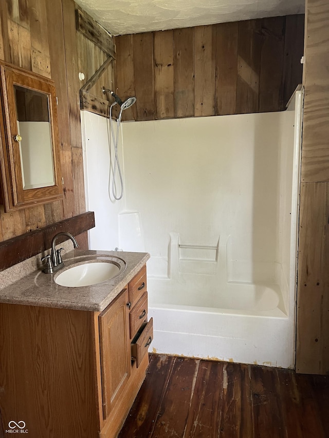 bathroom with wooden walls, vanity, and wood-type flooring