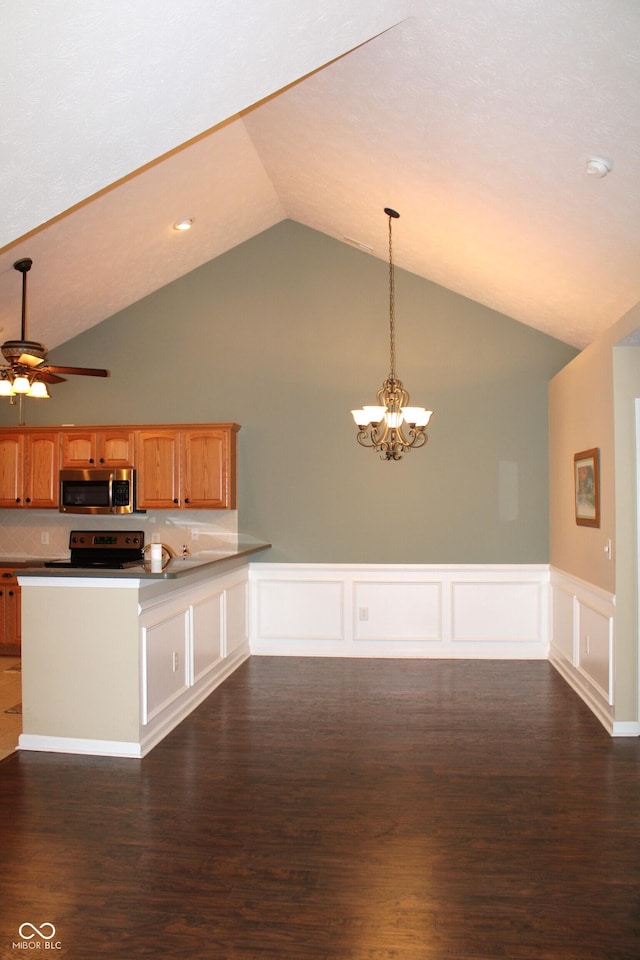 kitchen with decorative light fixtures, dark wood-type flooring, kitchen peninsula, and appliances with stainless steel finishes