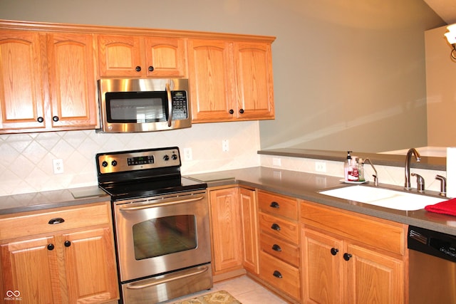 kitchen featuring sink, backsplash, stainless steel appliances, and light tile patterned floors