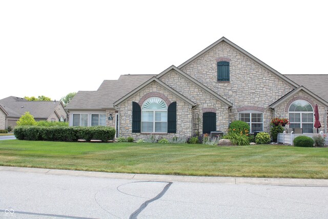 french country inspired facade featuring a front lawn