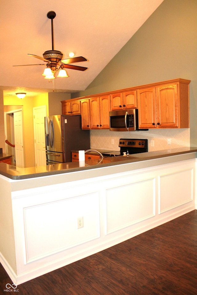 kitchen with lofted ceiling, dark hardwood / wood-style flooring, ceiling fan, stainless steel appliances, and decorative backsplash