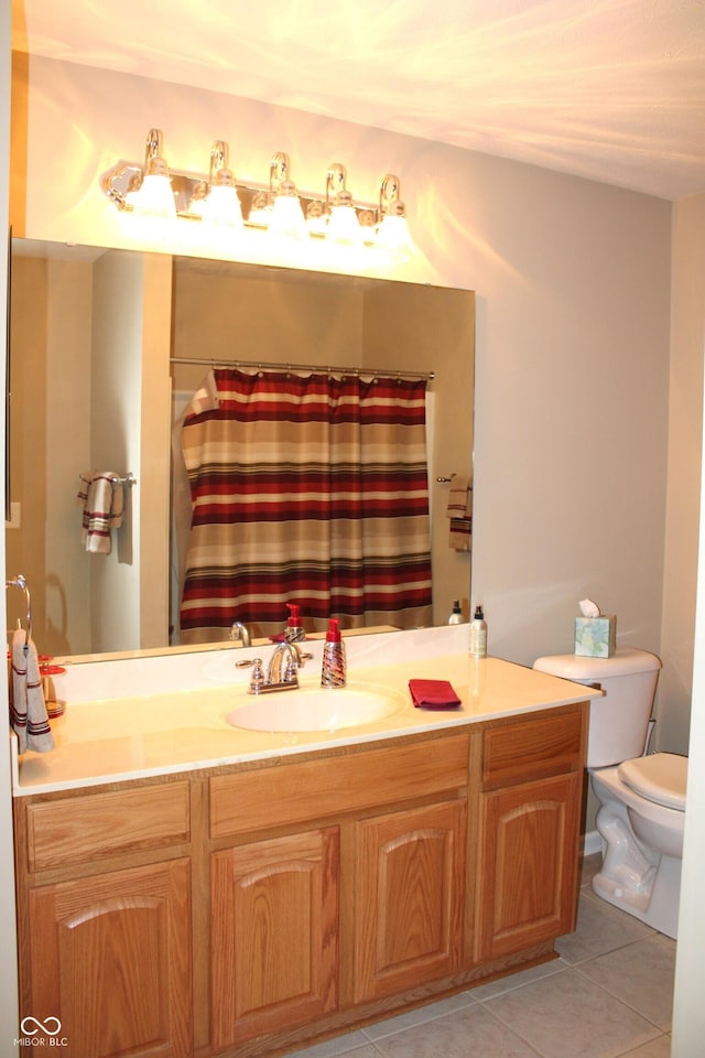 bathroom with tile patterned flooring, vanity, toilet, and walk in shower