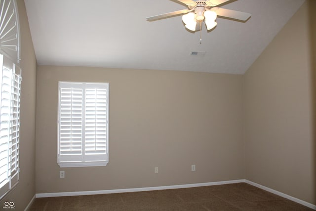 empty room featuring dark colored carpet, lofted ceiling, and ceiling fan