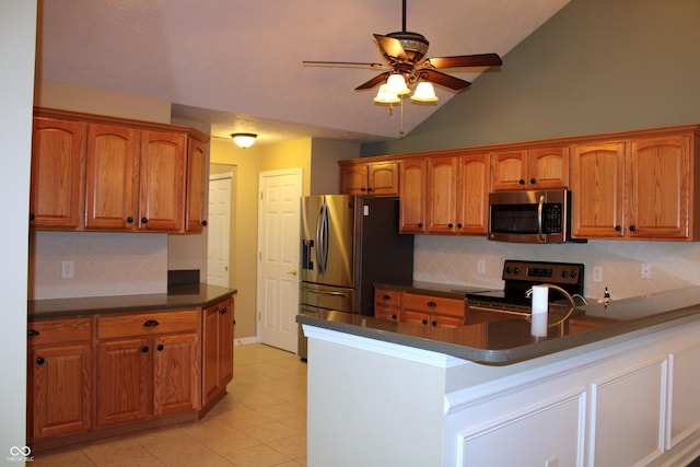 kitchen with light tile patterned flooring, vaulted ceiling, appliances with stainless steel finishes, kitchen peninsula, and ceiling fan