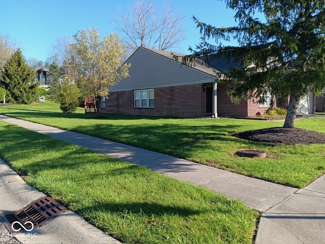 view of side of home with brick siding and a yard