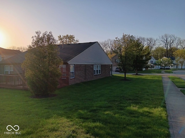 property exterior at dusk featuring a lawn