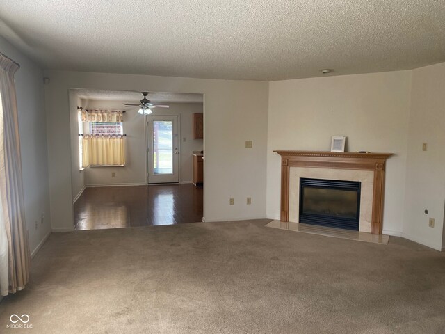 unfurnished living room with hardwood / wood-style floors, ceiling fan, a textured ceiling, and a fireplace