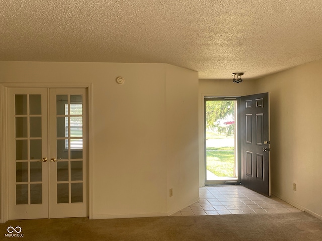 carpeted foyer featuring a textured ceiling and french doors