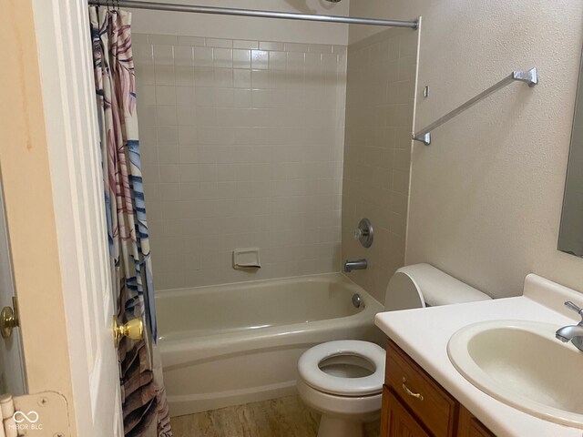 full bathroom featuring hardwood / wood-style flooring, toilet, vanity, and shower / tub combo