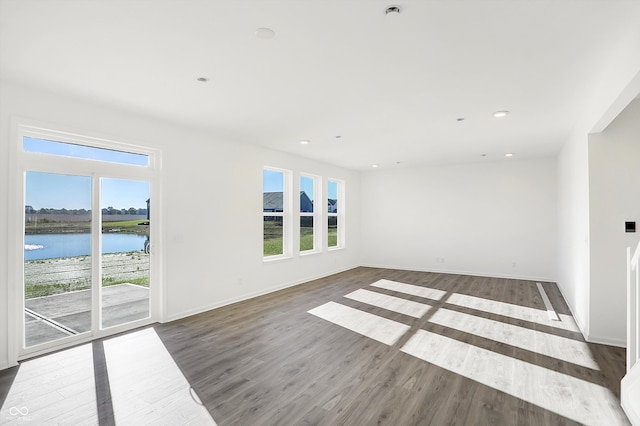 spare room featuring dark hardwood / wood-style flooring and a water view