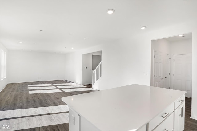 interior space with hardwood / wood-style floors, a kitchen island, and white cabinetry