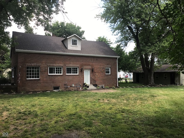 rear view of house featuring a lawn