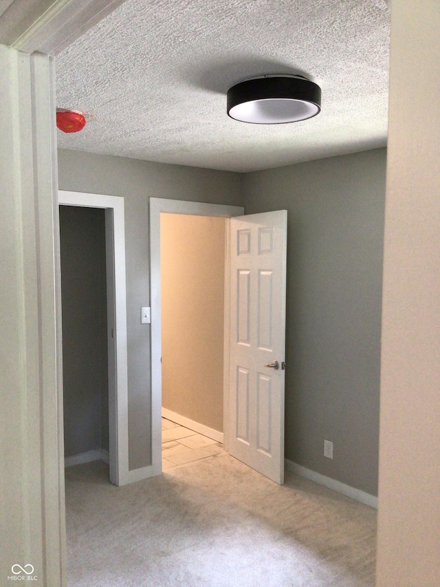 unfurnished bedroom featuring light colored carpet and a textured ceiling