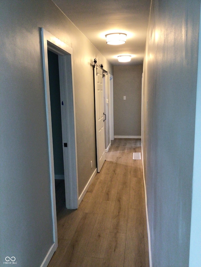 hallway featuring a barn door and hardwood / wood-style floors