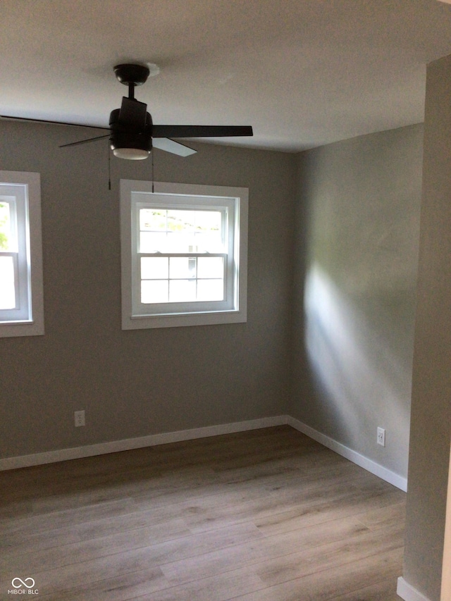 unfurnished room featuring ceiling fan, light hardwood / wood-style flooring, and a healthy amount of sunlight