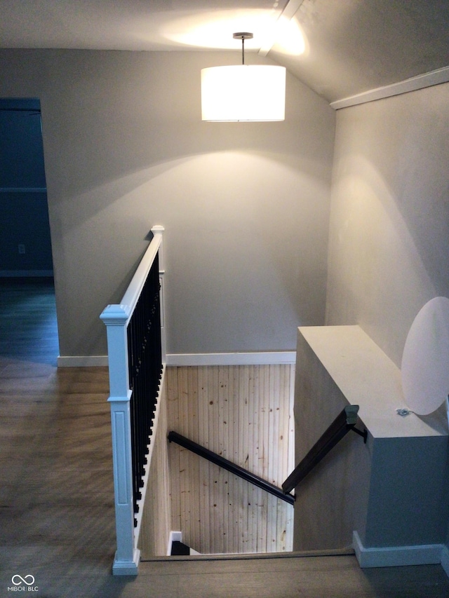 stairway featuring lofted ceiling and hardwood / wood-style floors