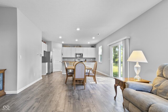 dining room with light wood-type flooring, baseboards, and recessed lighting