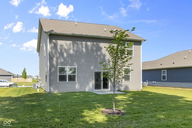 rear view of property featuring a lawn and central AC unit