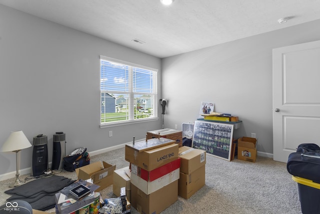 interior space featuring visible vents, light carpet, baseboards, and a textured ceiling