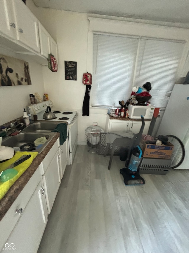 kitchen featuring white cabinetry, sink, light hardwood / wood-style floors, and white appliances