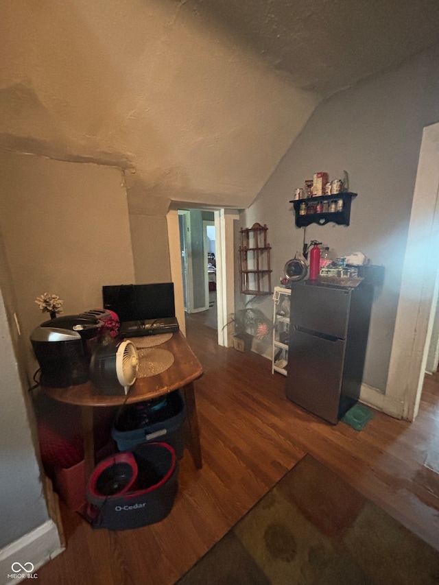 interior space featuring hardwood / wood-style flooring and vaulted ceiling