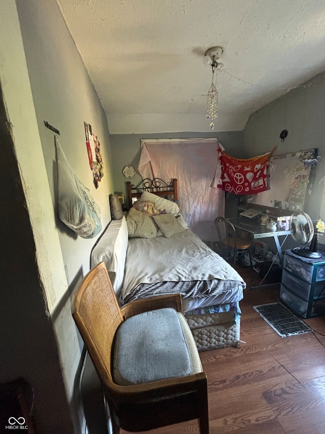 bedroom with a textured ceiling, dark hardwood / wood-style floors, and ceiling fan