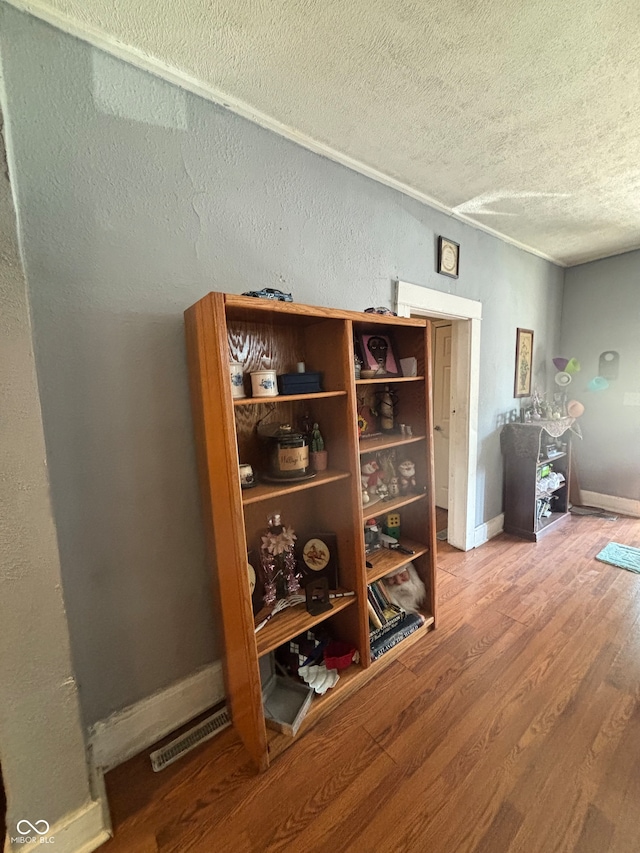 interior space with a textured ceiling and hardwood / wood-style flooring