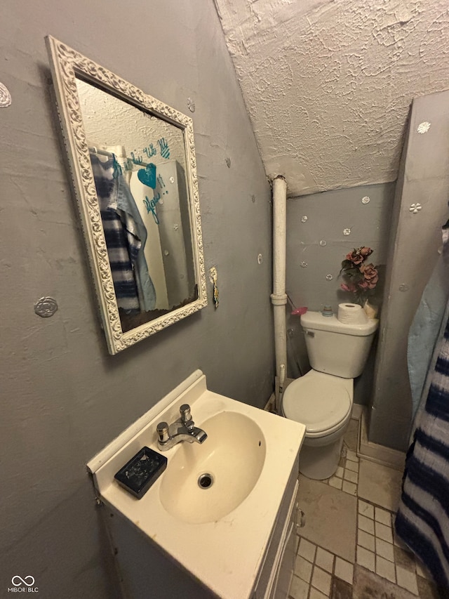 bathroom featuring vanity, toilet, and a textured ceiling