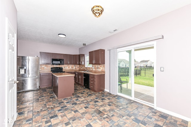 kitchen with decorative backsplash, dark brown cabinets, sink, black appliances, and a kitchen island