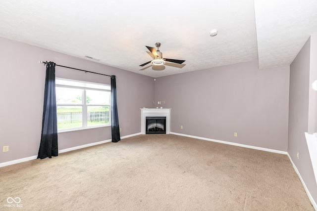 unfurnished living room featuring a textured ceiling, light colored carpet, and ceiling fan