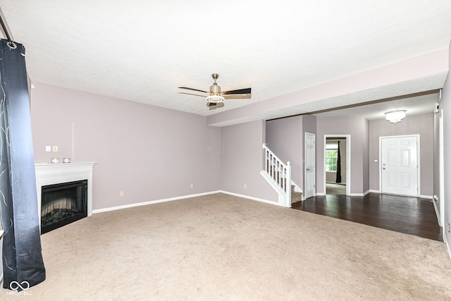 unfurnished living room featuring carpet and ceiling fan