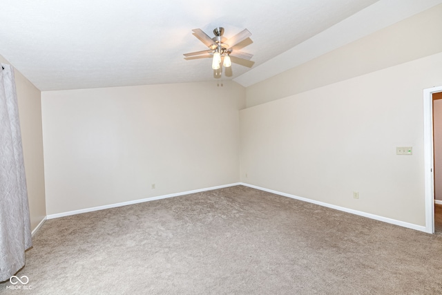 carpeted empty room with vaulted ceiling and ceiling fan