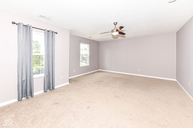 spare room featuring carpet flooring, ceiling fan, and a healthy amount of sunlight