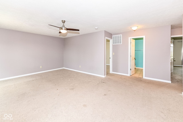 carpeted empty room featuring ceiling fan and a textured ceiling