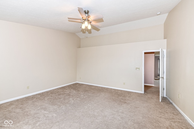 carpeted spare room featuring ceiling fan and vaulted ceiling