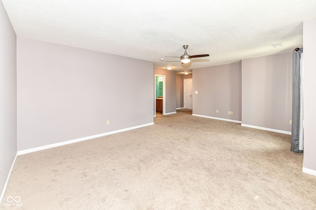 carpeted spare room featuring ceiling fan and a textured ceiling