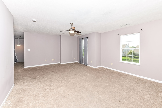 carpeted spare room with a textured ceiling and ceiling fan