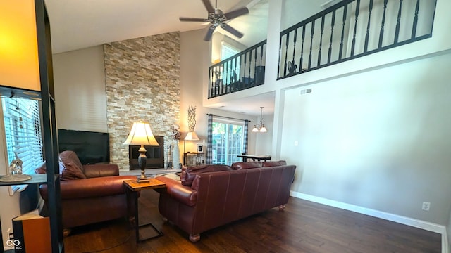 living room featuring high vaulted ceiling, dark wood-type flooring, and ceiling fan with notable chandelier