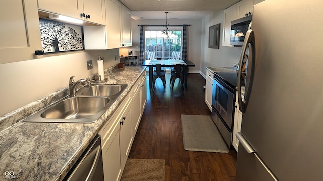 kitchen with pendant lighting, white cabinets, sink, dark hardwood / wood-style floors, and stainless steel appliances